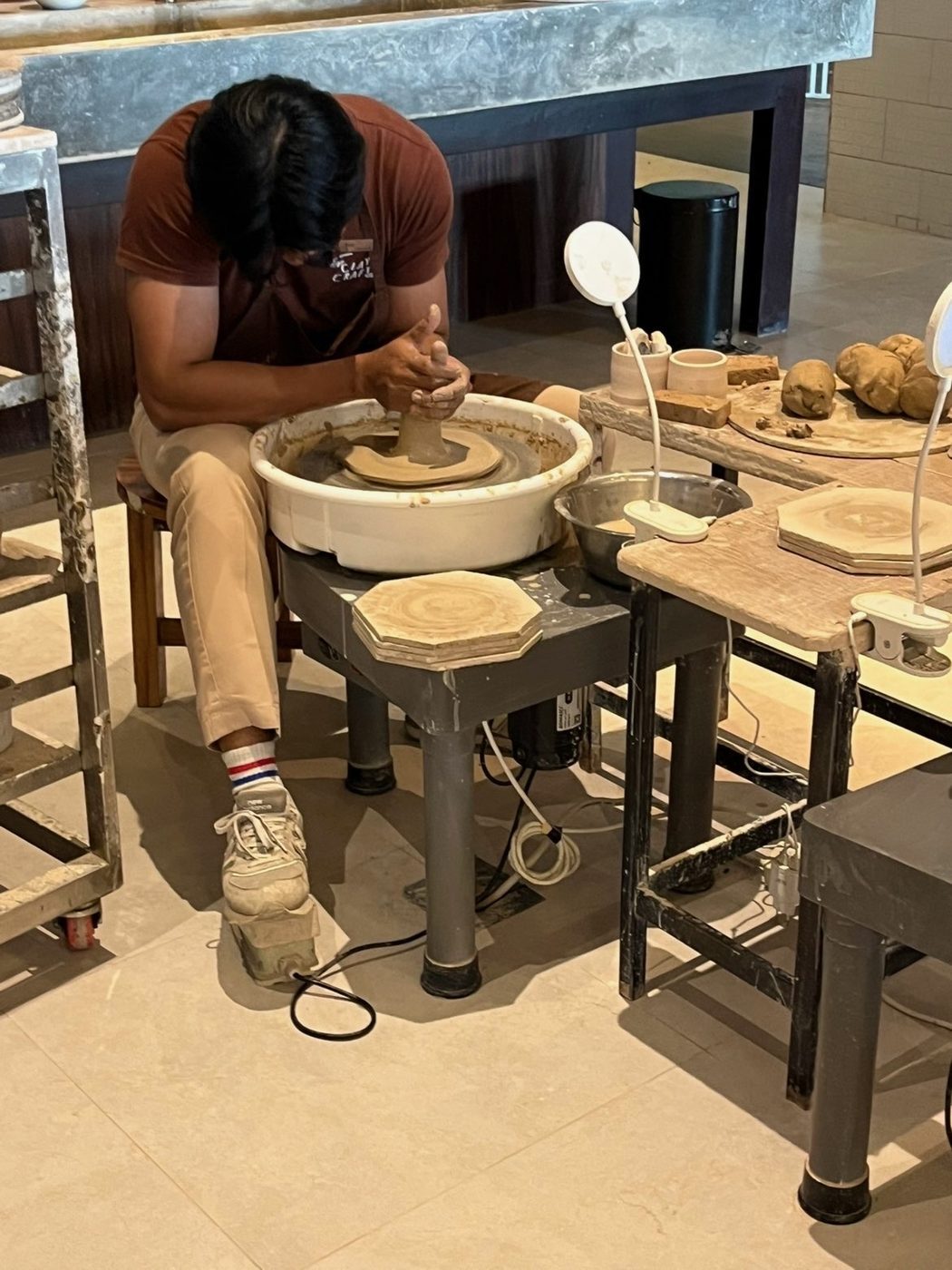 Artisan centrant une motte d'argile sur le tour dans un atelier de poterie à Bali